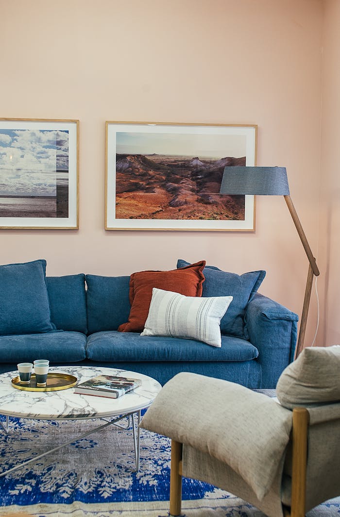 Contemporary living room with blue sofa, artwork, and decor for a cozy ambiance.